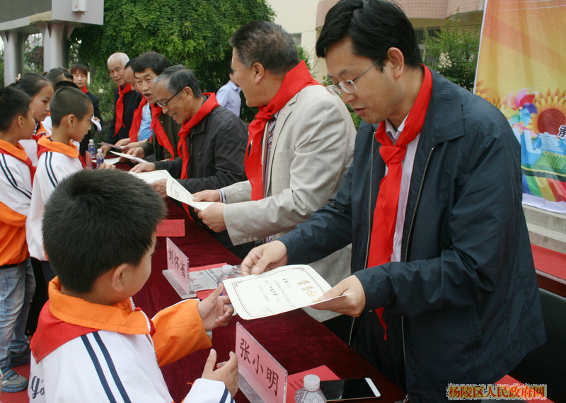 张小明为获奖优秀少先队个人颁奖。